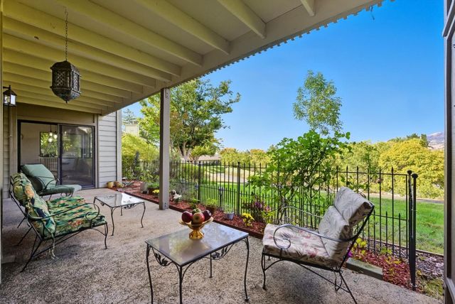 a view of a patio with couches table and chairs and potted plants