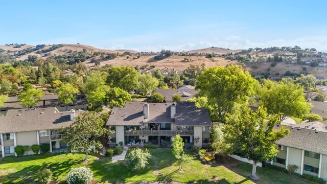 an aerial view of a house with a mountain in the background