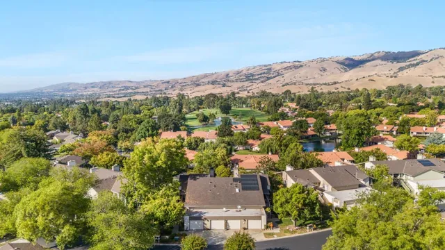 an aerial view of residential houses with outdoor space and trees