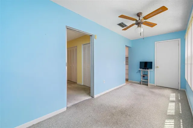a view of an empty room with a ceiling fan