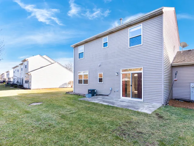 a backyard of a house with table and chairs
