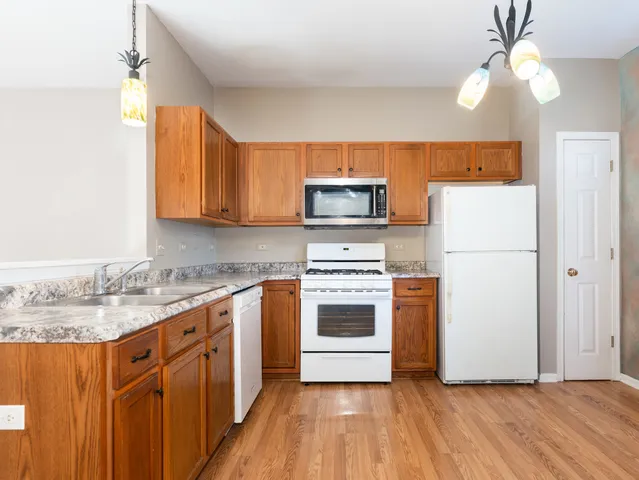 a kitchen with a refrigerator a stove a microwave oven with cabinets and wooden floor