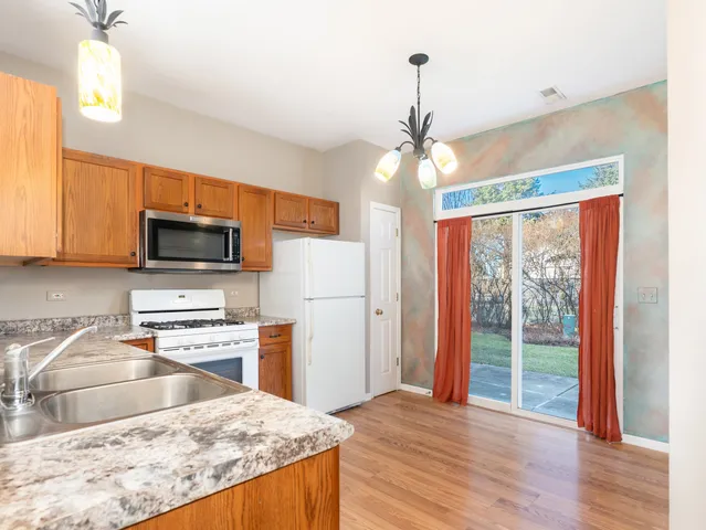 a kitchen with stainless steel appliances granite countertop a stove refrigerator and microwave