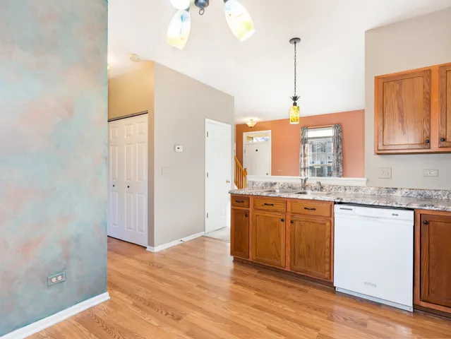 a kitchen with stainless steel appliances granite countertop a sink a refrigerator a stove and a wooden floors