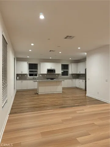 a view of kitchen with cabinets microwave and stove