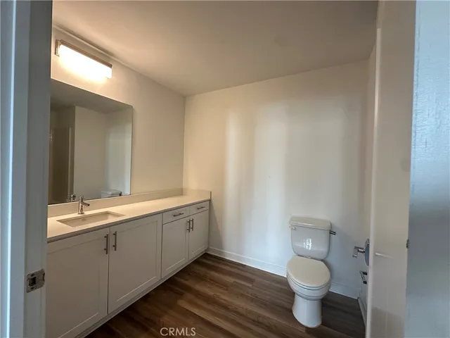 a bathroom with a granite countertop sink mirror vanity and toilet