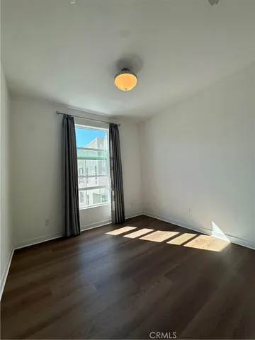 a view of a room with wooden floor and a window