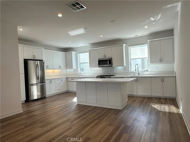 a kitchen with stainless steel appliances a refrigerator sink and cabinets
