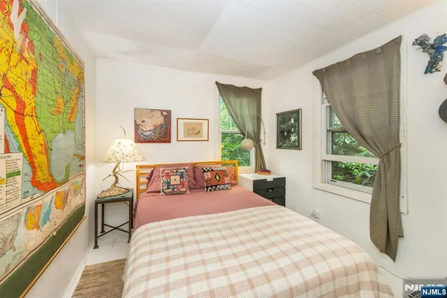 a bedroom with a bed and a large window with outer view