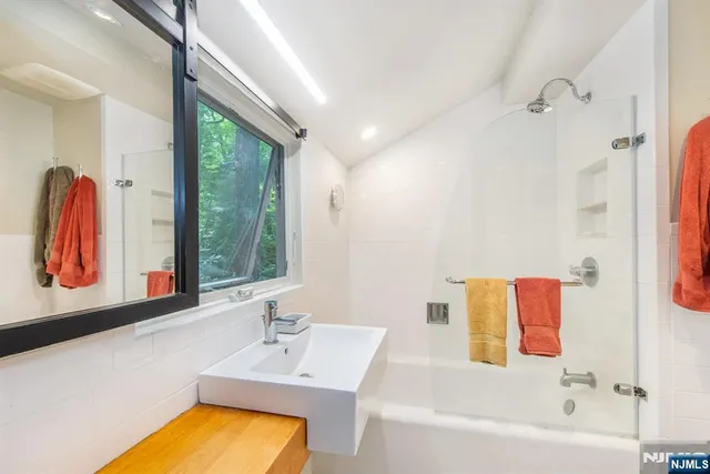 a bathroom with a tub sink and mirror