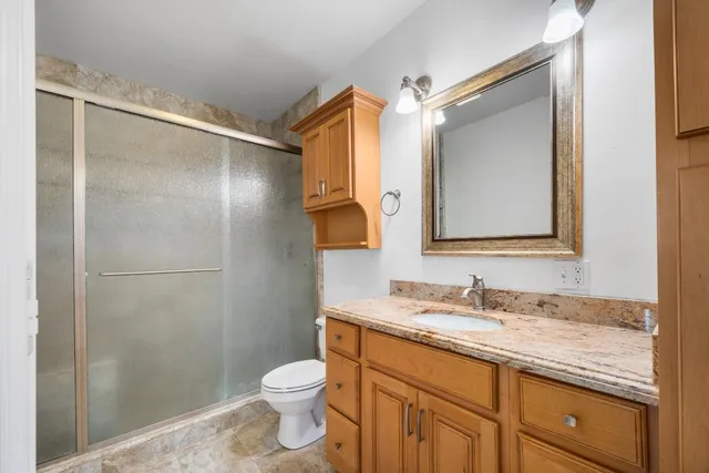 an aerial view of residential houses with outdoor space and trees all around