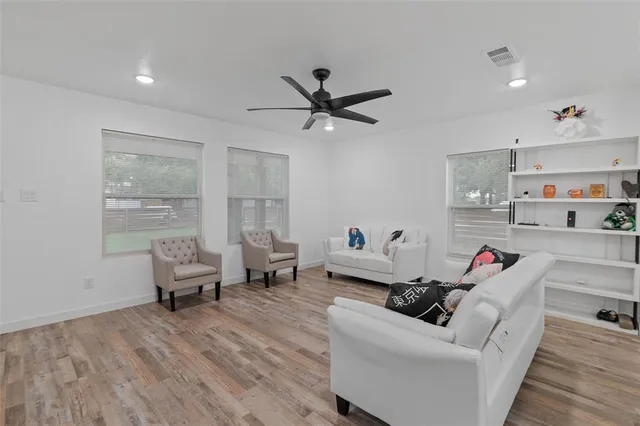 a living room with furniture and a wooden floor