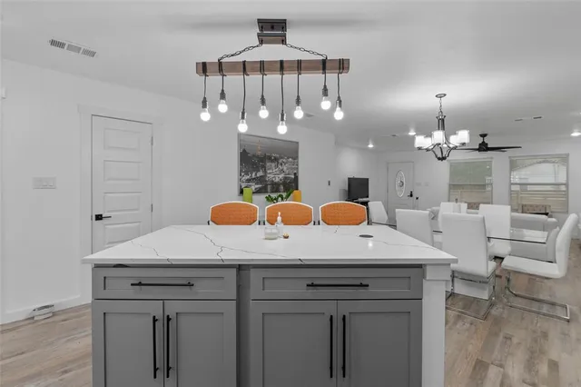 a view of a kitchen with a sink and chandelier