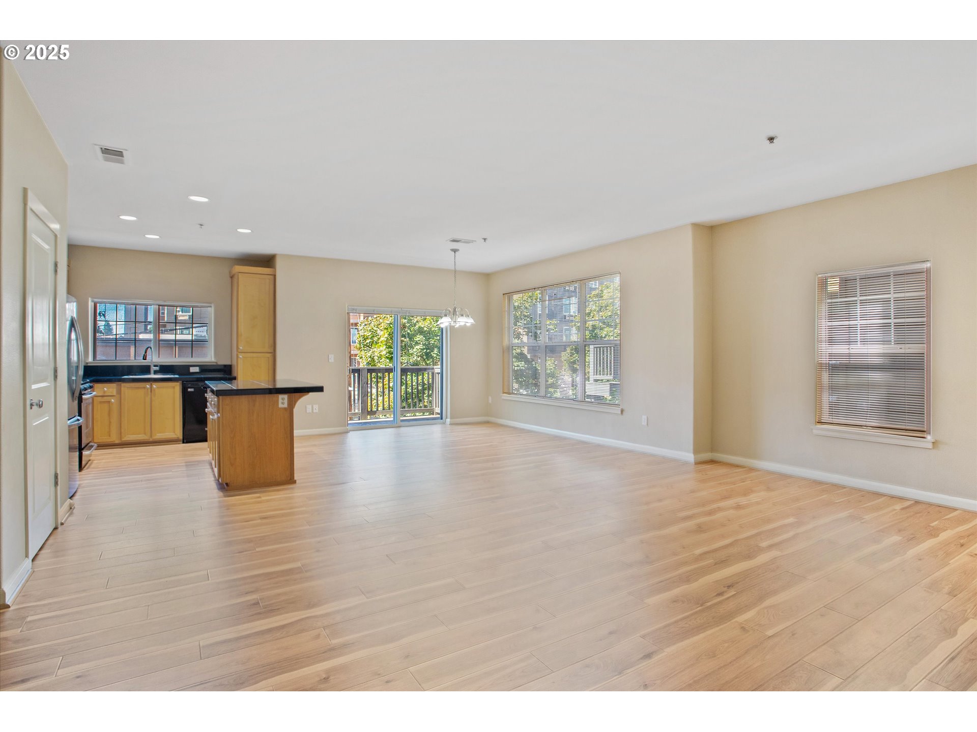 1000 Southwest 170th Avenue, Unit 201 Beaverton, OR 97003 - Photo 3 of 14 a view of an empty room with wooden floor and a kitchen