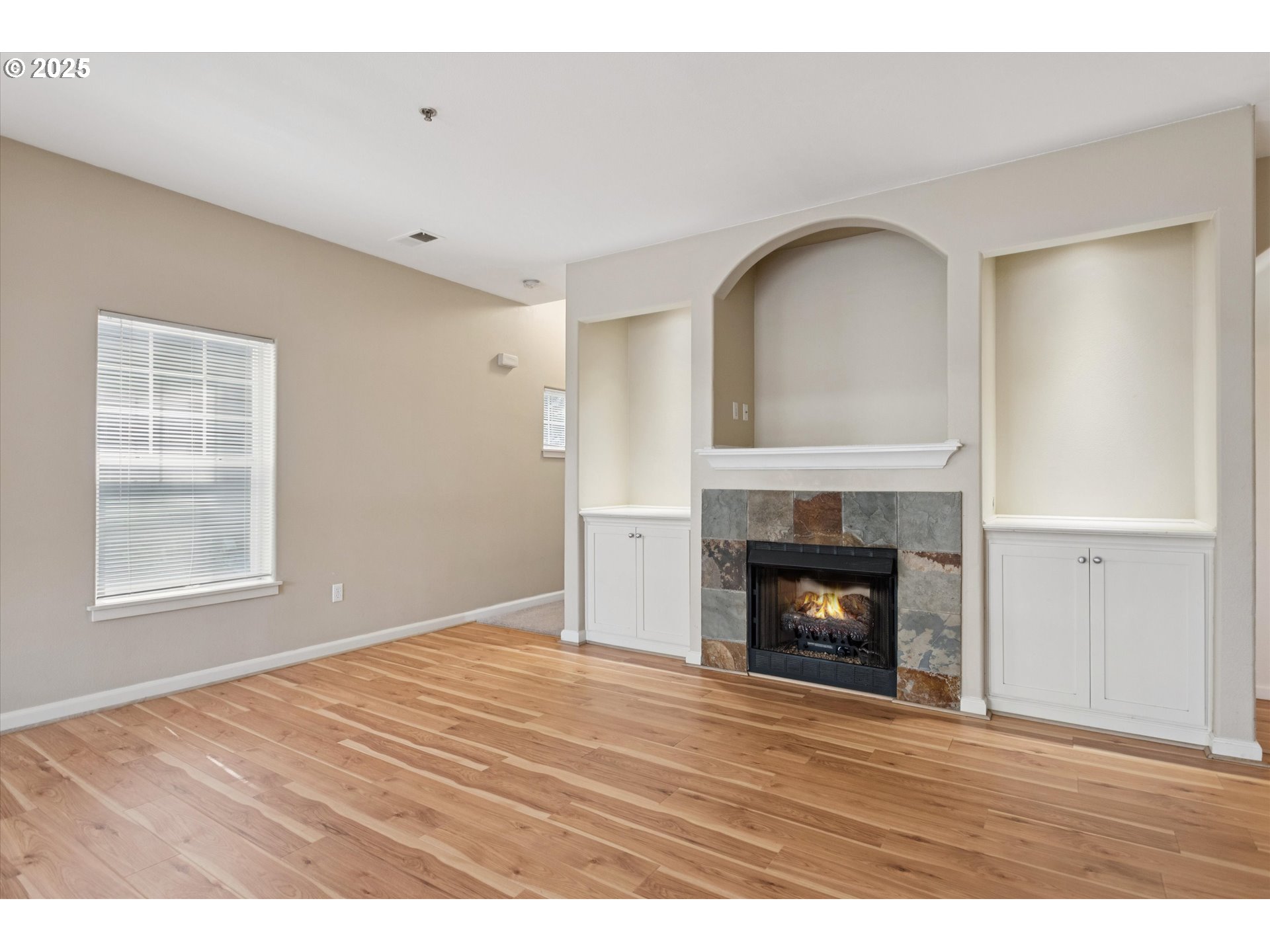 1000 Southwest 170th Avenue, Unit 201 Beaverton, OR 97003 - Photo 6 of 14 a view of an empty room with wooden floor fireplace and a window