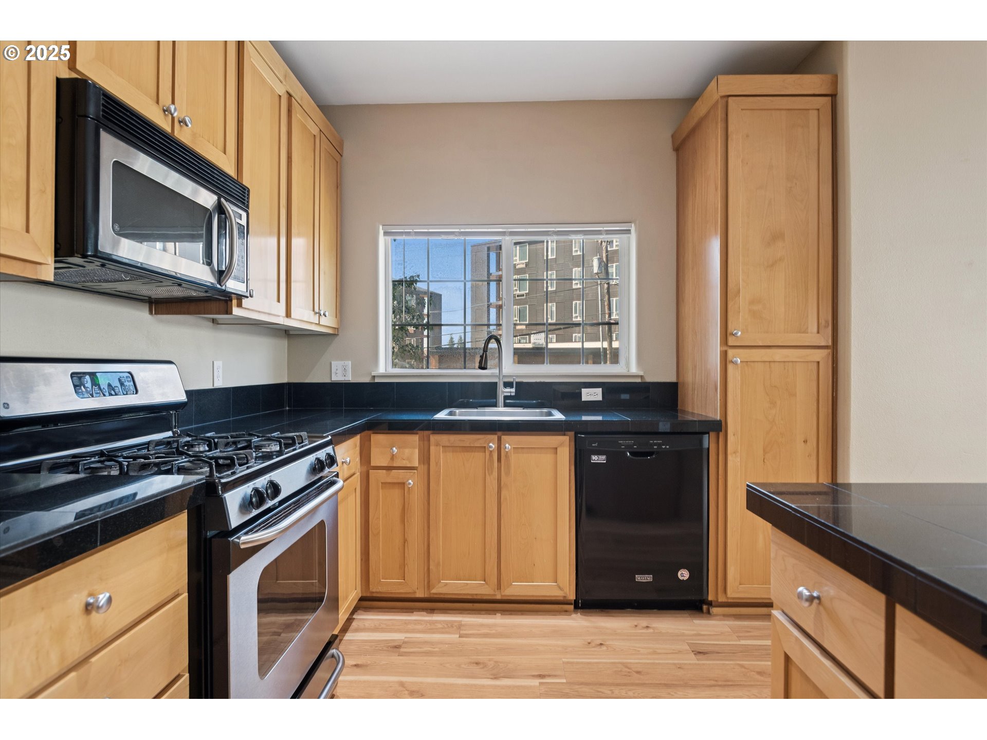 1000 Southwest 170th Avenue, Unit 201 Beaverton, OR 97003 - Photo 7 of 14 a kitchen with granite countertop a stove a sink and a microwave