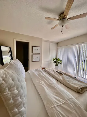 a bedroom with a large bed and a chandelier