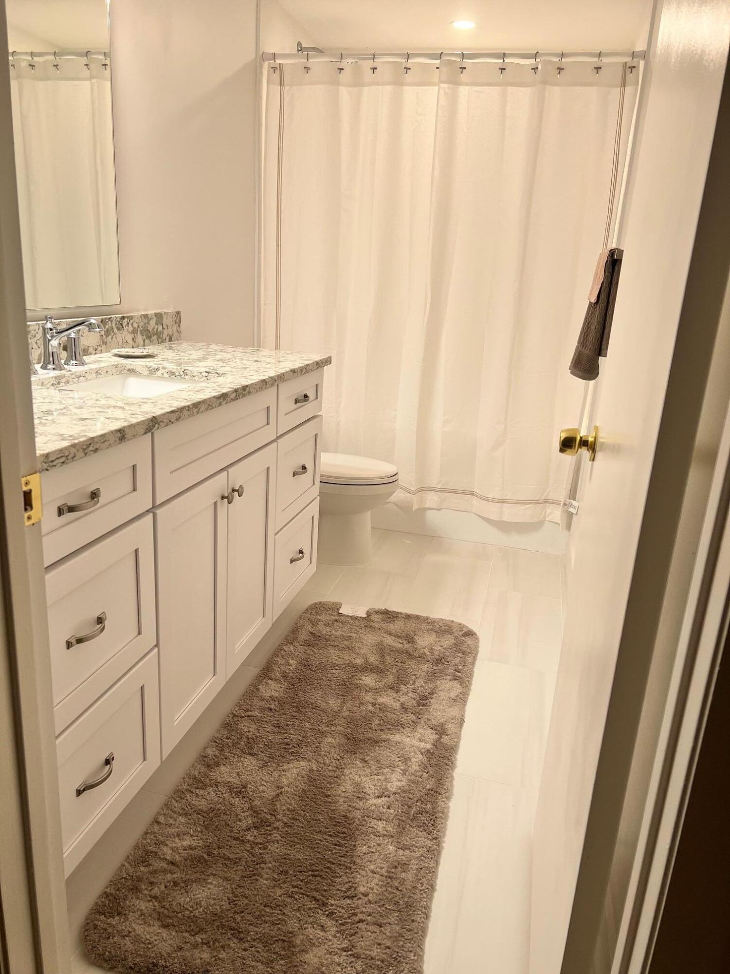 3105 31st Court, Unit 130D Jupiter, FL 33477 - Photo 15 of 24 a bathroom with a granite countertop sink and a mirror