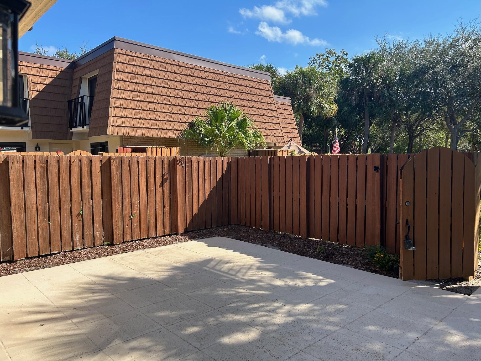 3105 31st Court, Unit 130D Jupiter, FL 33477 - Photo 3 of 24 a view of small house with wooden fence