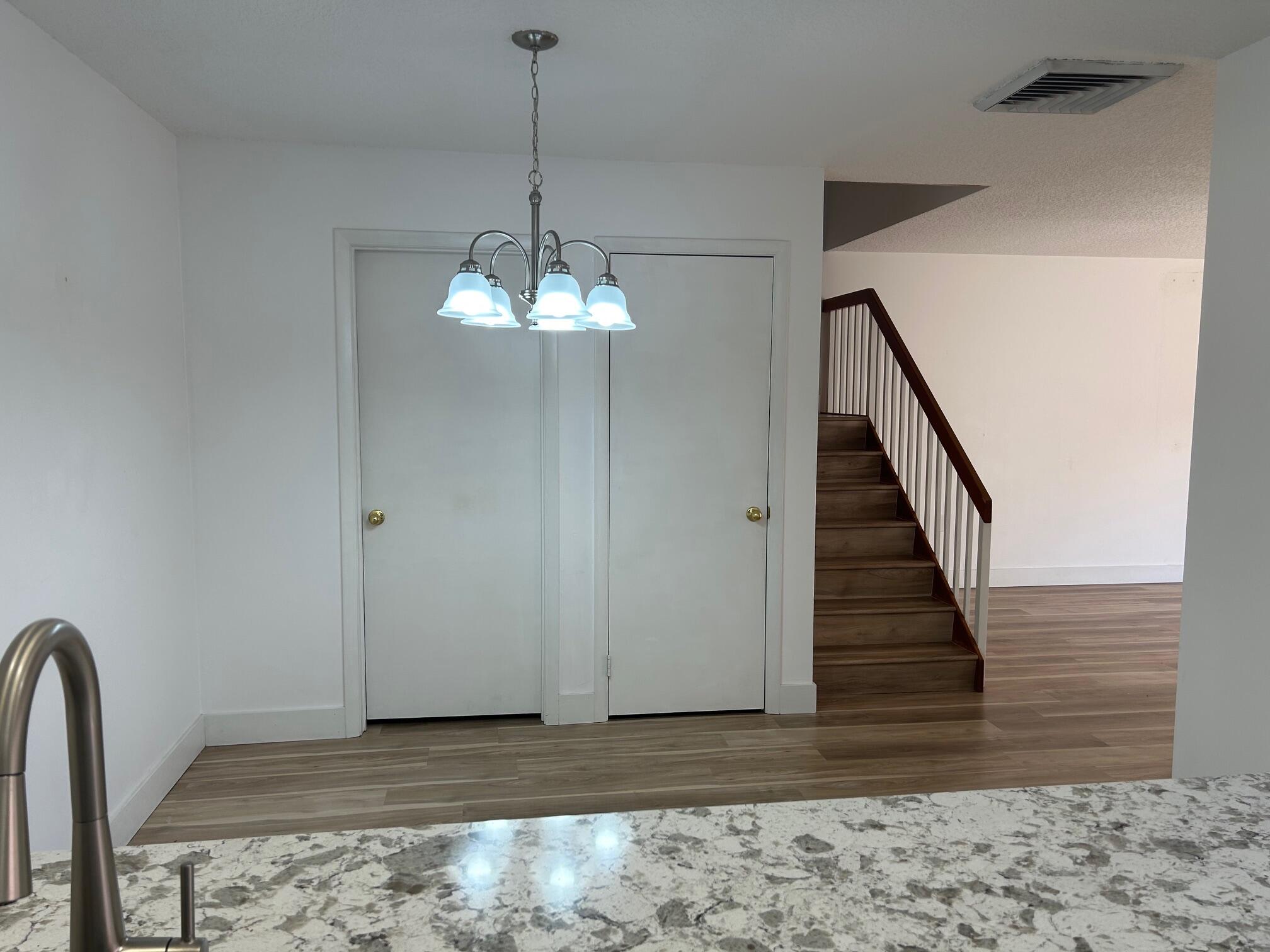 3105 31st Court, Unit 130D Jupiter, FL 33477 - Photo 5 of 24 a view of a hallway with a chandelier
