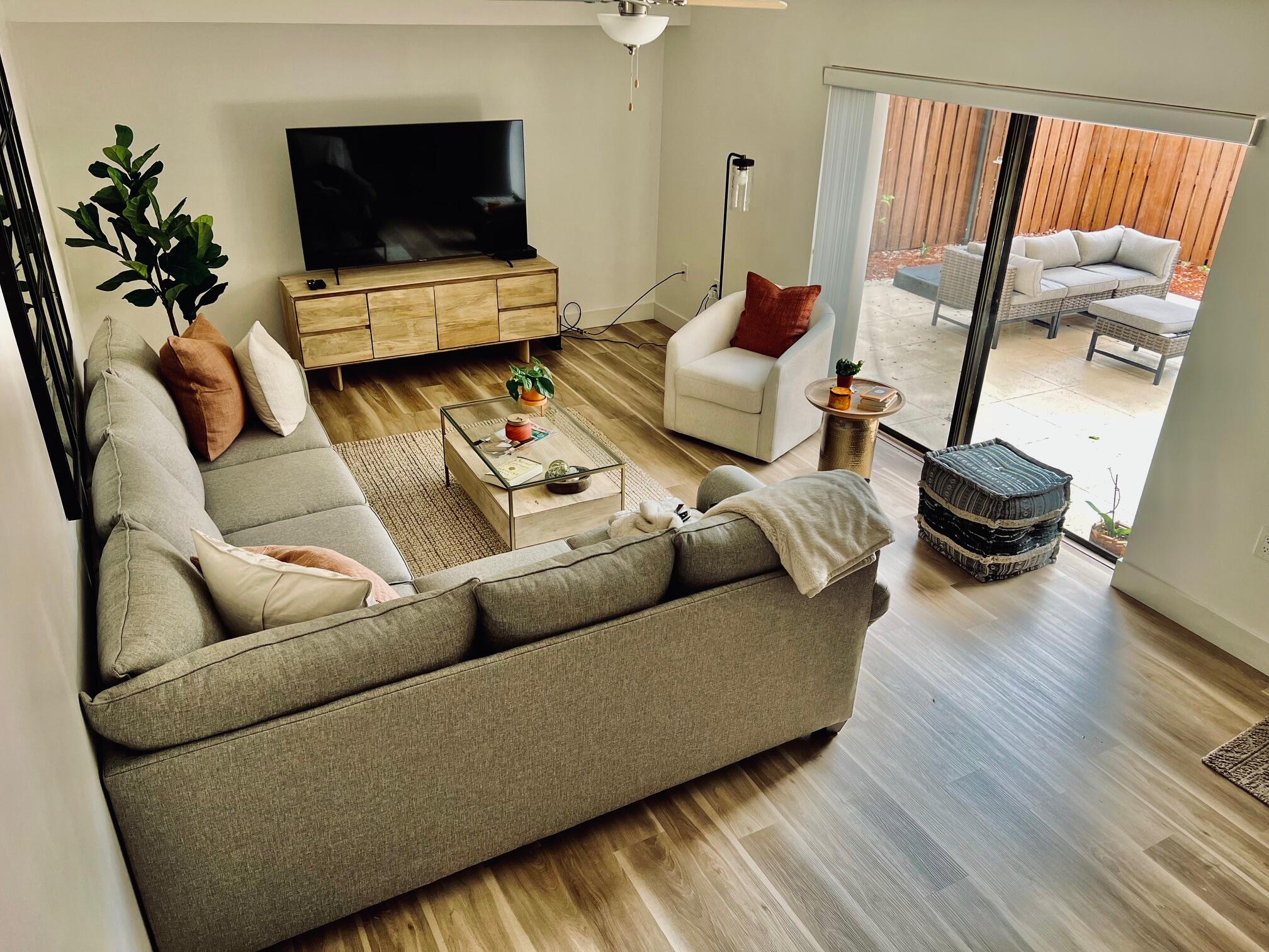 3105 31st Court, Unit 130D Jupiter, FL 33477 - Photo 7 of 24 a living room with furniture and a flat screen tv