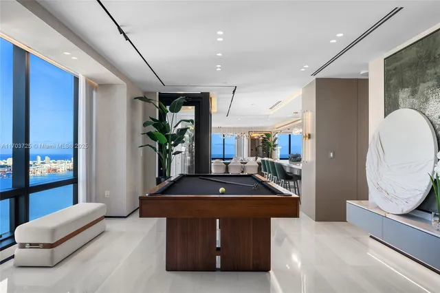 a living room with furniture a floor to ceiling window and potted plants