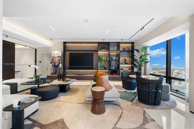 a dining room with furniture a chandelier and kitchen view