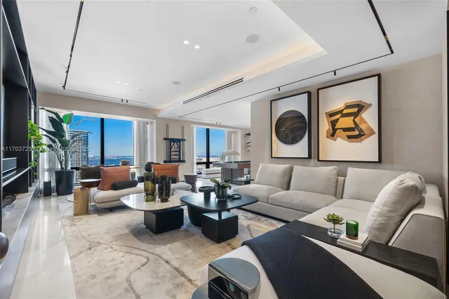 a living room with furniture a mirror a lamp and a large window