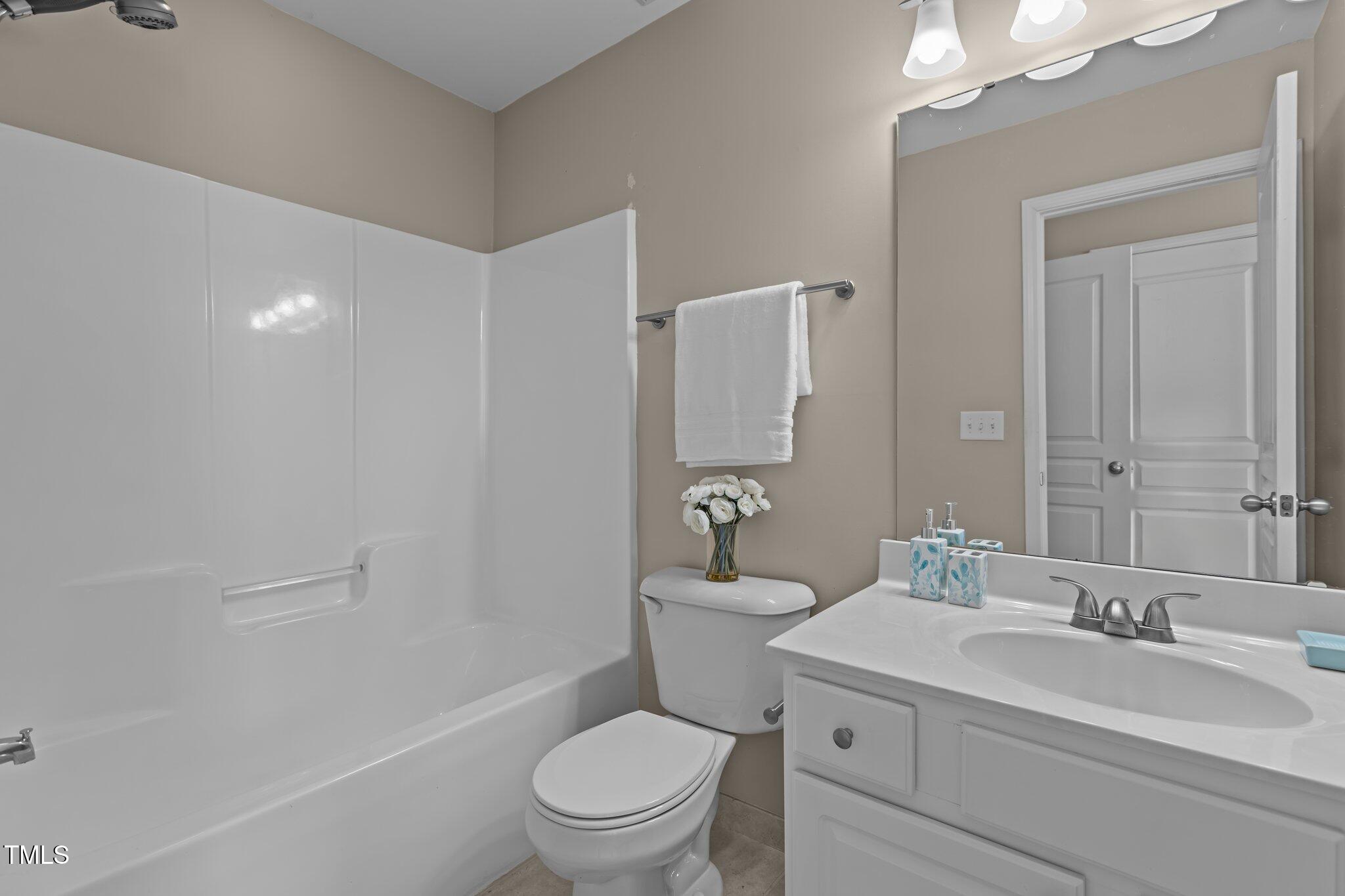 7850 Silverthread Lane Raleigh, NC 27617 - Photo 23 of 28 a bathroom with a toilet a sink a mirror and a shower