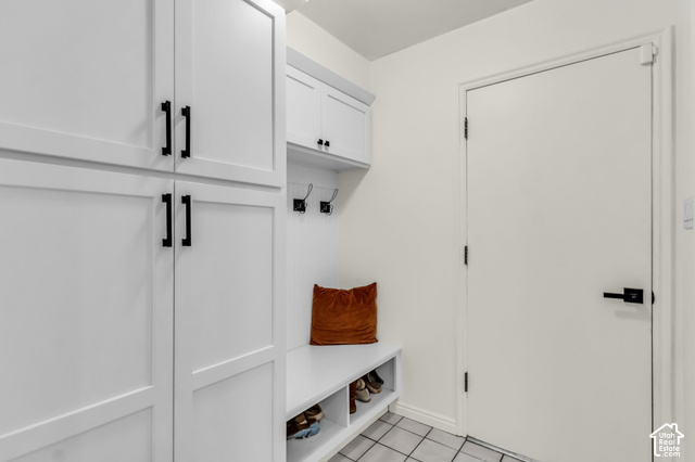 1073 Pineridge Road Sandy, UT 84094 - Photo 10 of 31 Built-in white cabinetry with matte black hardware, integrated bench seating, wall-mounted hooks, and tiled flooring
