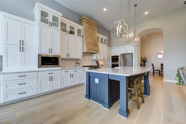 a kitchen with stainless steel appliances granite countertop a stove refrigerator and cabinets