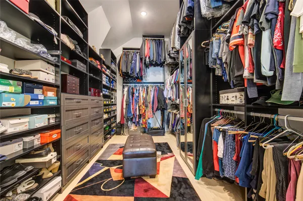 a view of walk in closet with clothes and shoes