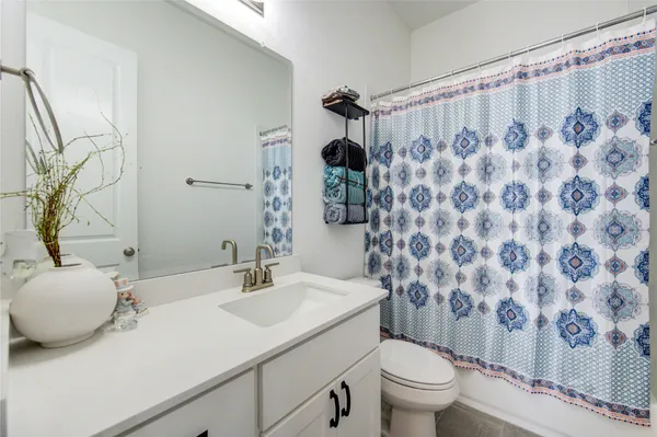 a bathroom with a sink toilet double vanity and shower