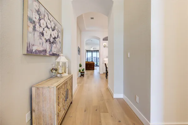 a view of a hallway with a white walls and wooden floor