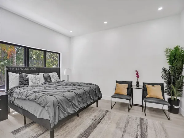 a bedroom with a bed and a potted plant on table