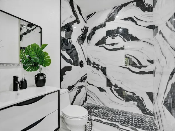 a bathroom with a sink and mirror with toilet