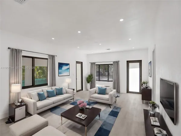 a living room with furniture flat screen tv and a large window