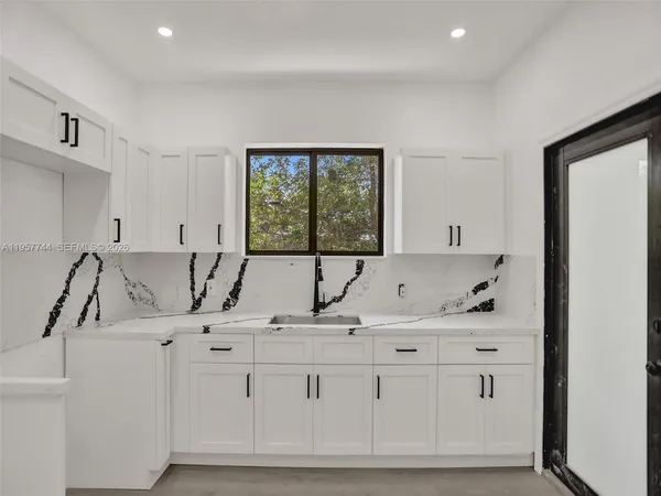 a kitchen with granite countertop a sink and a window