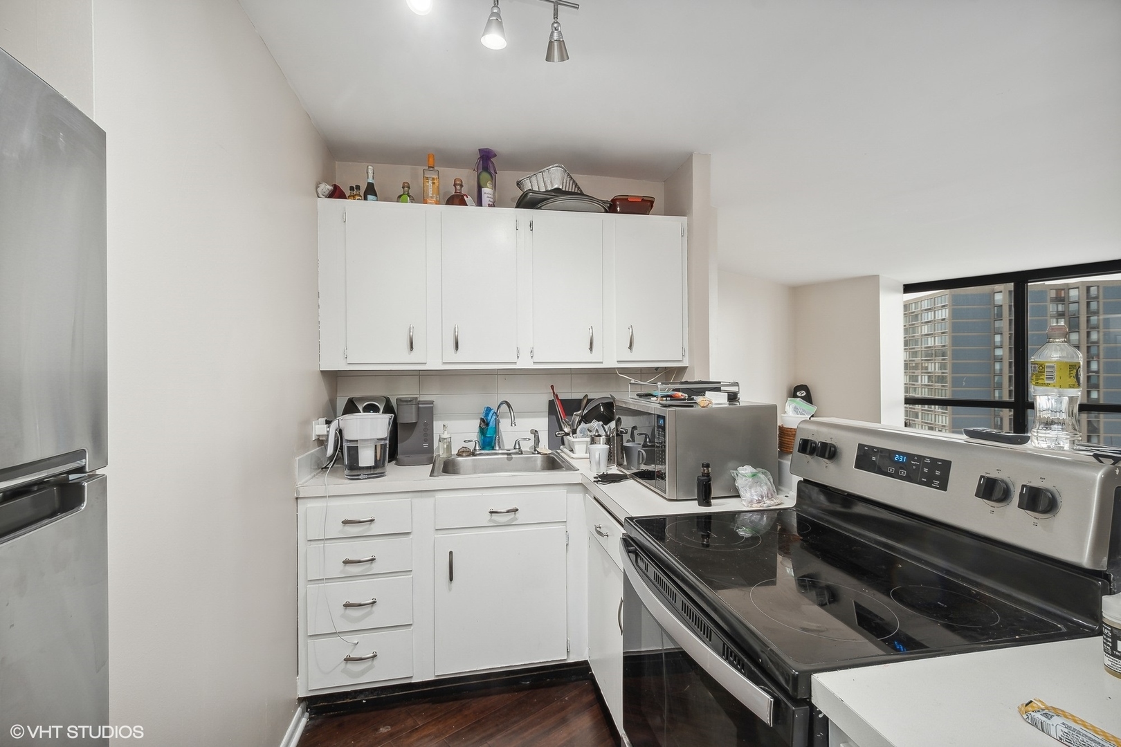 5415 North Sheridan Road, Unit 2103 Chicago, IL 60640 - Photo 3 of 12 a kitchen with granite countertop a sink stove and cabinets