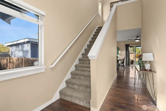 a view of staircase with lots of frames on wall and wooden floor