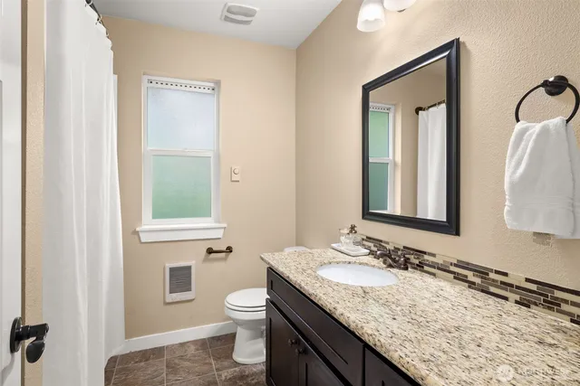 a bathroom with a granite countertop sink and a mirror