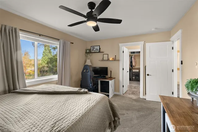 a bedroom with a bed and a large window