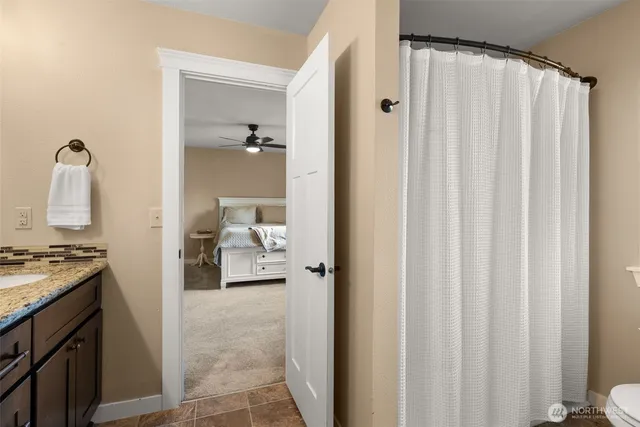 a en suite bathroom with a granite countertop sink and a mirror