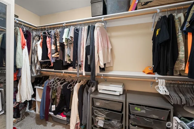 a view of walk in closet with clothes and shoes