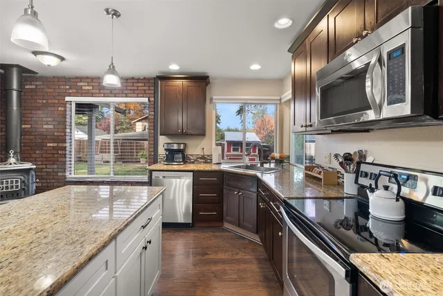 a kitchen with stainless steel appliances granite countertop a sink stove and refrigerator