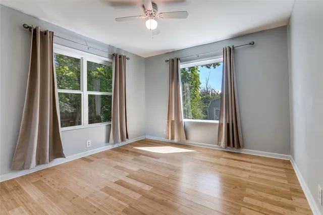 a view of a big room with wooden floor fan and windows