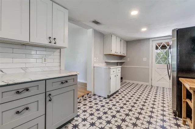 a kitchen with granite countertop white cabinets and stainless steel appliances