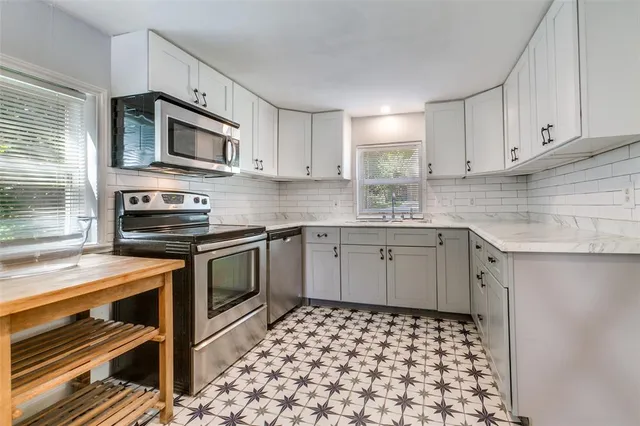 a kitchen with stainless steel appliances a stove a sink and a microwave