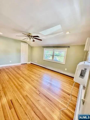 a view of a livingroom with wooden floor and a ceiling fan