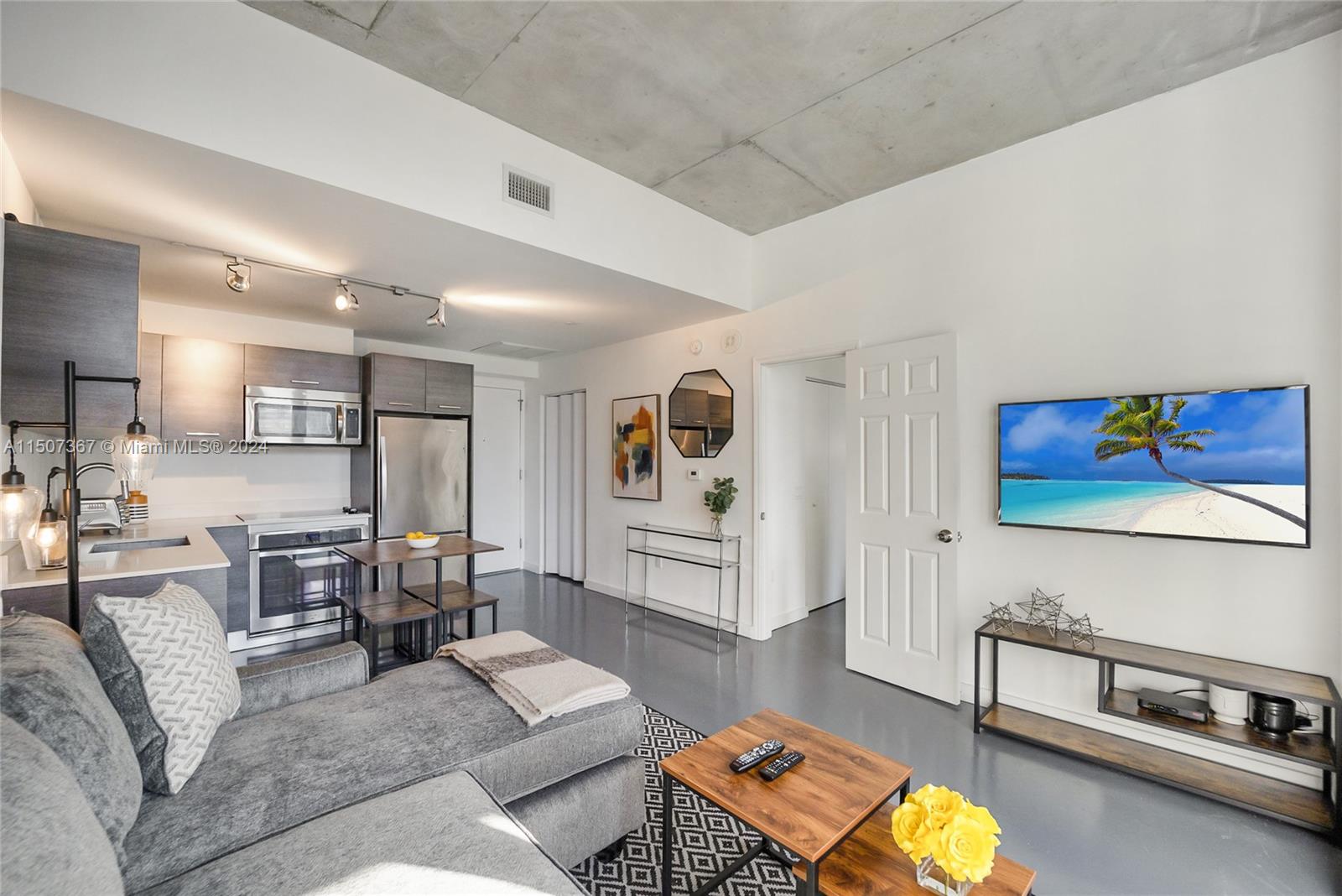 151 Southeast 1st Street, Unit 2109 Miami, FL 33131 - Photo 6 of 13 a living room with furniture and kitchen view with wooden floor